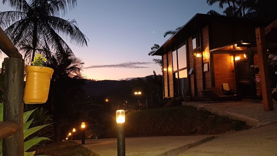 Fachada da Cabana Angillyn ao entardecer com iluminação acolhedora